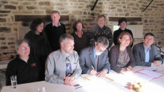 Au centre, le président du Musée François-Pilote, Rosaire Ouellet, signant l’entente en compagnie du directeur Luc Saint-Amand. Photo : Ouest-France